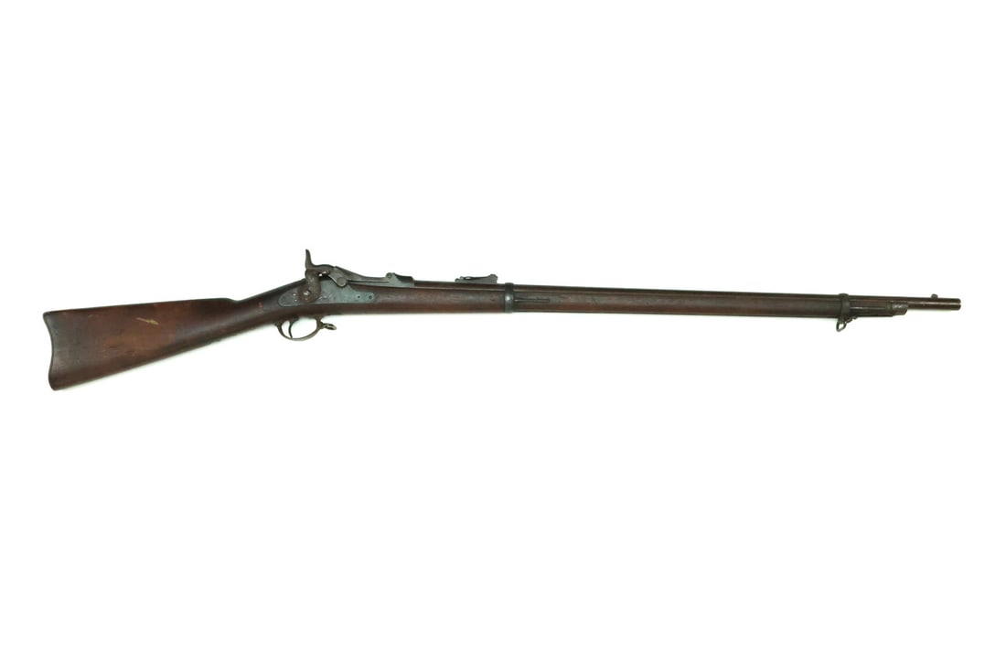 US Indian Wars M1873 SPRINGFIELD TRAPDOOR Rifle: Model 1873 infantry rifle featuring a barrel with a deeply oxidized patina throughout the metal surfaces, a functional single shot breech block displaying crisp model stamps and serial number 85288. T