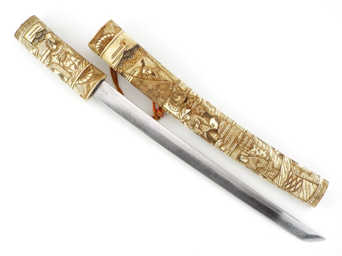 Very fine Japanese Meiji Era Tanto Dagger Elaborately CARVED MOUNTINGS: Blade exhibits scattered oxidation, hilt comprises of very fine carving depicting communal village scenes showing expected age cracking and yellowed patina. Matching scabbard features continuous high 
