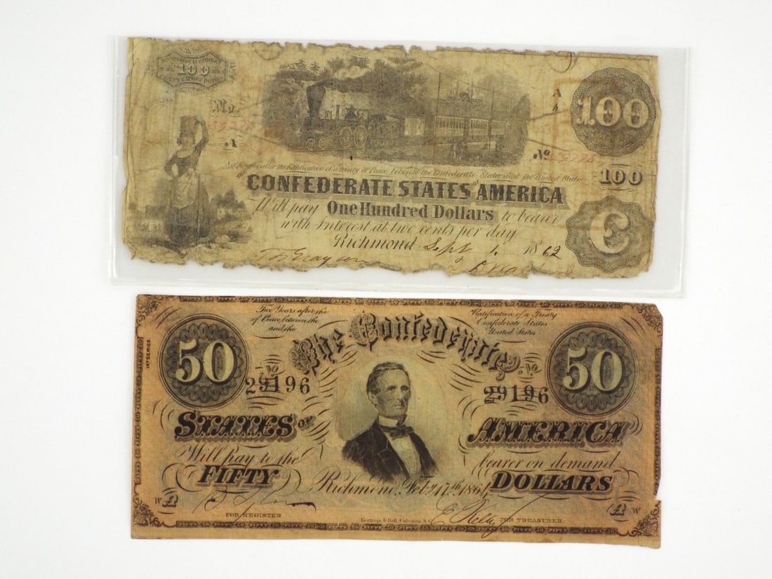 Two Confederate Notes: Pair of Confederate States of America banknotes featuring an 1862 interest bearing one hundred dollar note with a central train vignette, exhibiting heavy handling wear and ragged margins, plus an