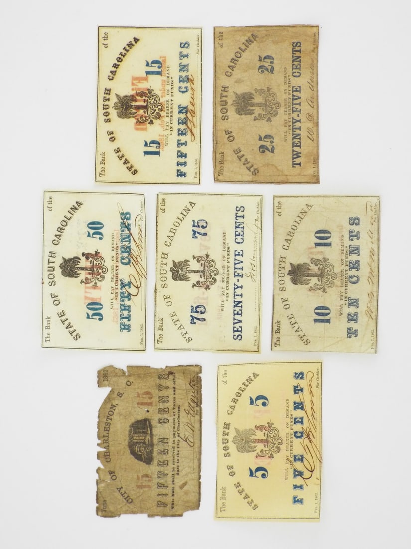 Seven S.C. Confederate Notes: Assembled group of seven paper notes displaying variable toning and handling wear consistent with circulation. The 1862 Charleston fifteen cents note exhibits a tattered perimeter, heavy creasing and