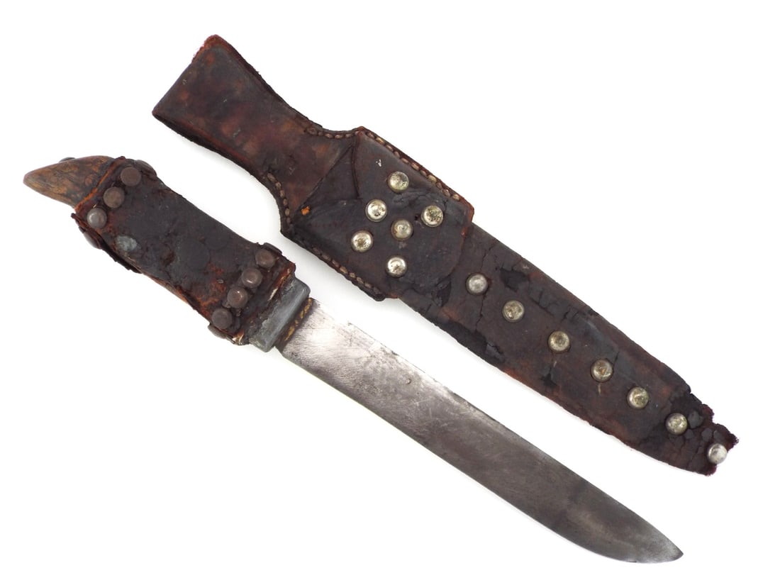 Indian Plains 18th-19th C. TACK DECORATED TRADE KNIFE & Sheath: Broad steel trade blade displays dark honest patina throughout. The hilt features a rawhide wrapped grip over wood, terminating in a carved bird’s-head pommel showing some loss with substantial age 