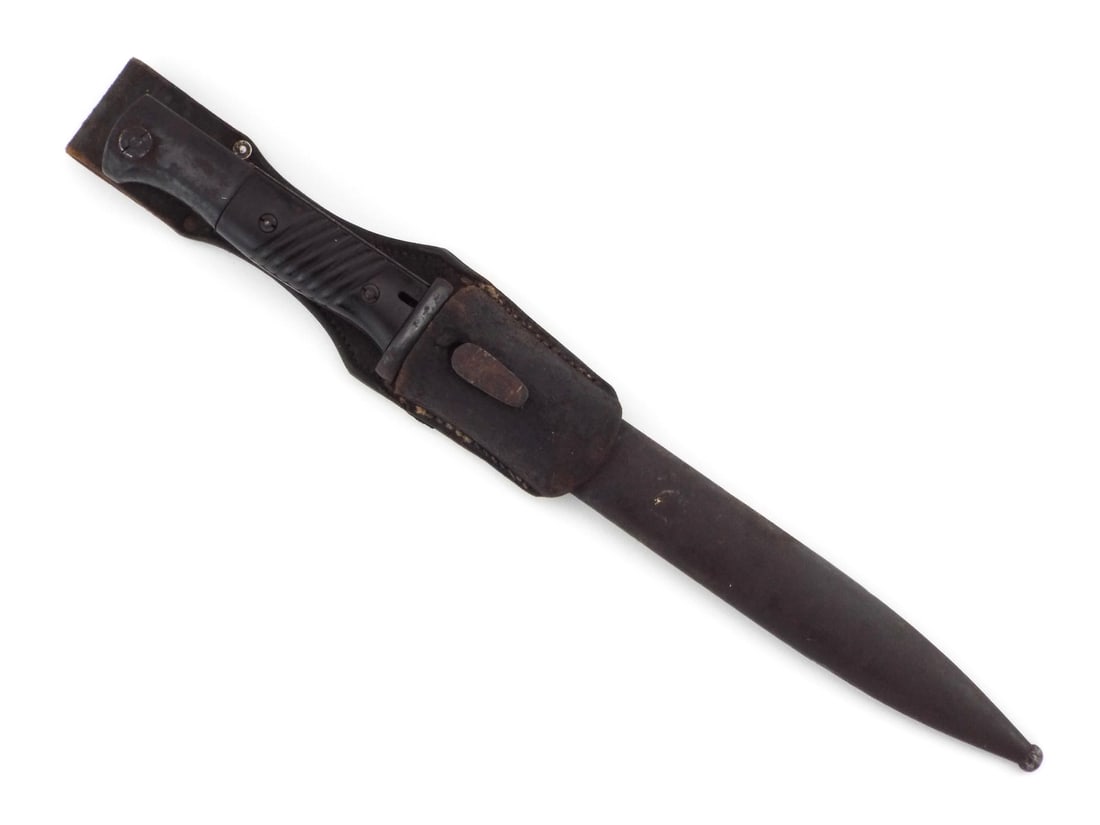 German WWII K98 Bayonet: Standard issue combat bayonet features a single edged blued steel blade with deep fullers, ricasso stamped 40 wkc maker mark and numbered 8185, showing scattered oxidation and age related wear. Hilt r
