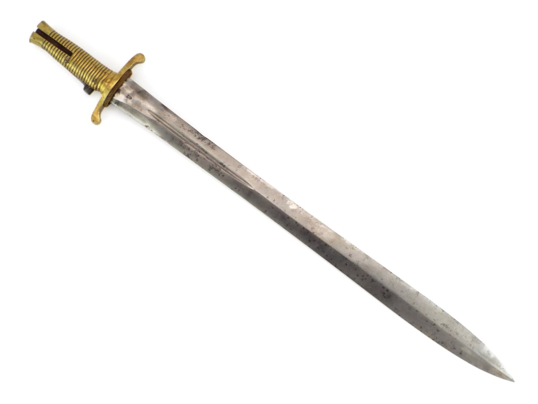 British Crimean War Brunswick Rifle Bayonet ROYAL SMALL ARMS MARKS: Double edged spear point steel blade displays localized darkening and fine scale oxidation with a short central fuller near the ricasso. Solid brass hilt features ribbed grips and an S-curved crossgua