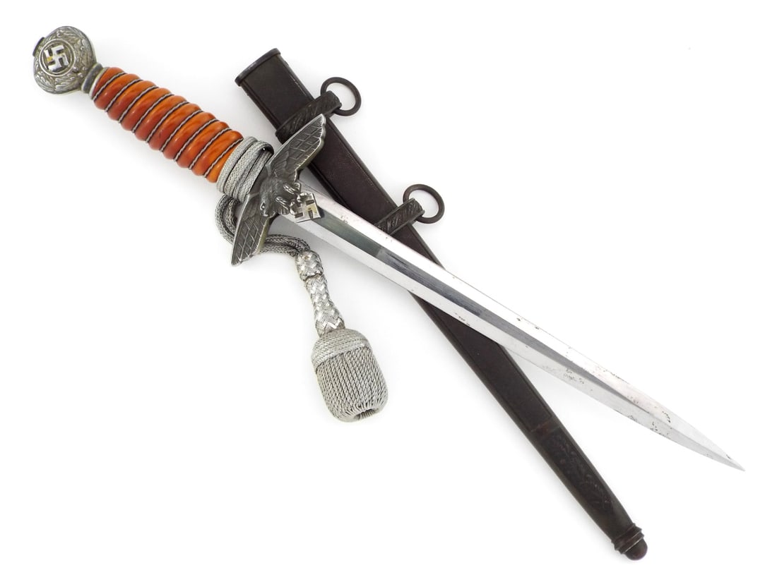 German WWII 2nd Model Luftwaffe Officer Dagger By CARL EICKHORN Solingen with Portepee: Bright double edged steel blade shows light surface scuffing and runner marks with stamped manufacturer logo. Deep orange celluloid grip remains tight with intact wire wrap, flanked by an aluminum eag