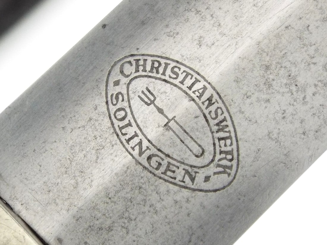 Rare German WWII NSKK Dagger By CHRISTIANSWERK SOLINGEN: Early production nickel-silver blade shows prominent cross graining, faint runner marks and light spotty oxidation, featuring the acid etched motto translated as everything for Germany. Dark wood grip