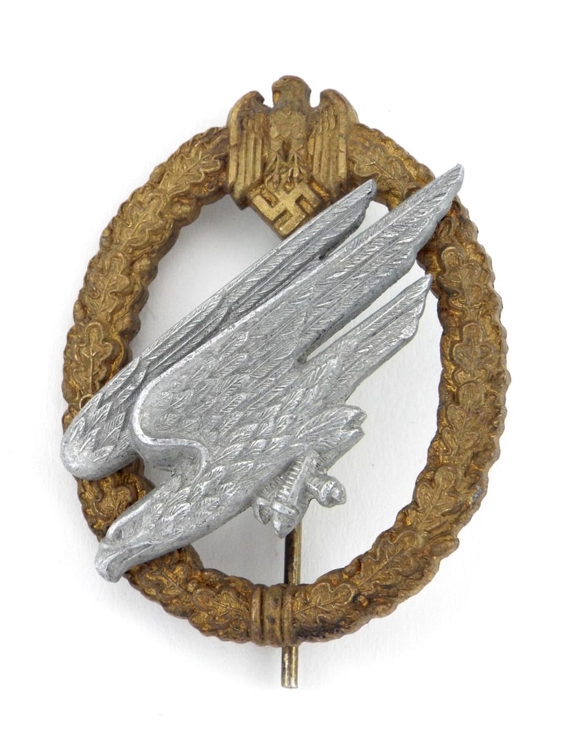 German WWII Glider Pilot Badge GILT & SILVERED FINISH & Oval Wreath: Luftwaffe glider pilot badge constructed with a silvered eagle riveted to a gilded oak leaf wreath. Reverse shows dual dome rivets, vertical pin assembly, top block hinge and bottom catch. Surface exh