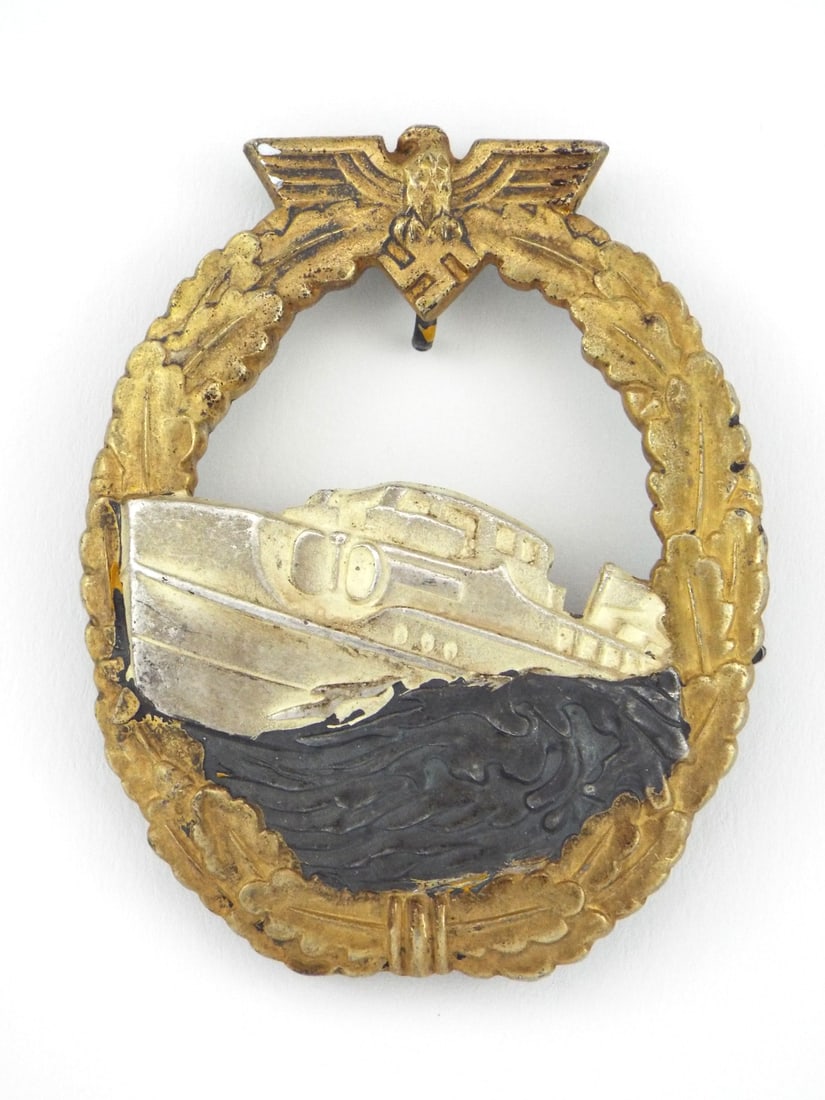 German WWII Fast Attack Craft War Badge SCHWERIN BERLIN 68 Gilt Tombak & Nickel Silver: Tombak constructed first pattern naval war badge features a beautifully retained gilded oak leaf wreath displaying minor age patina and crisp detailing. Central nickel silver fast attack craft retains