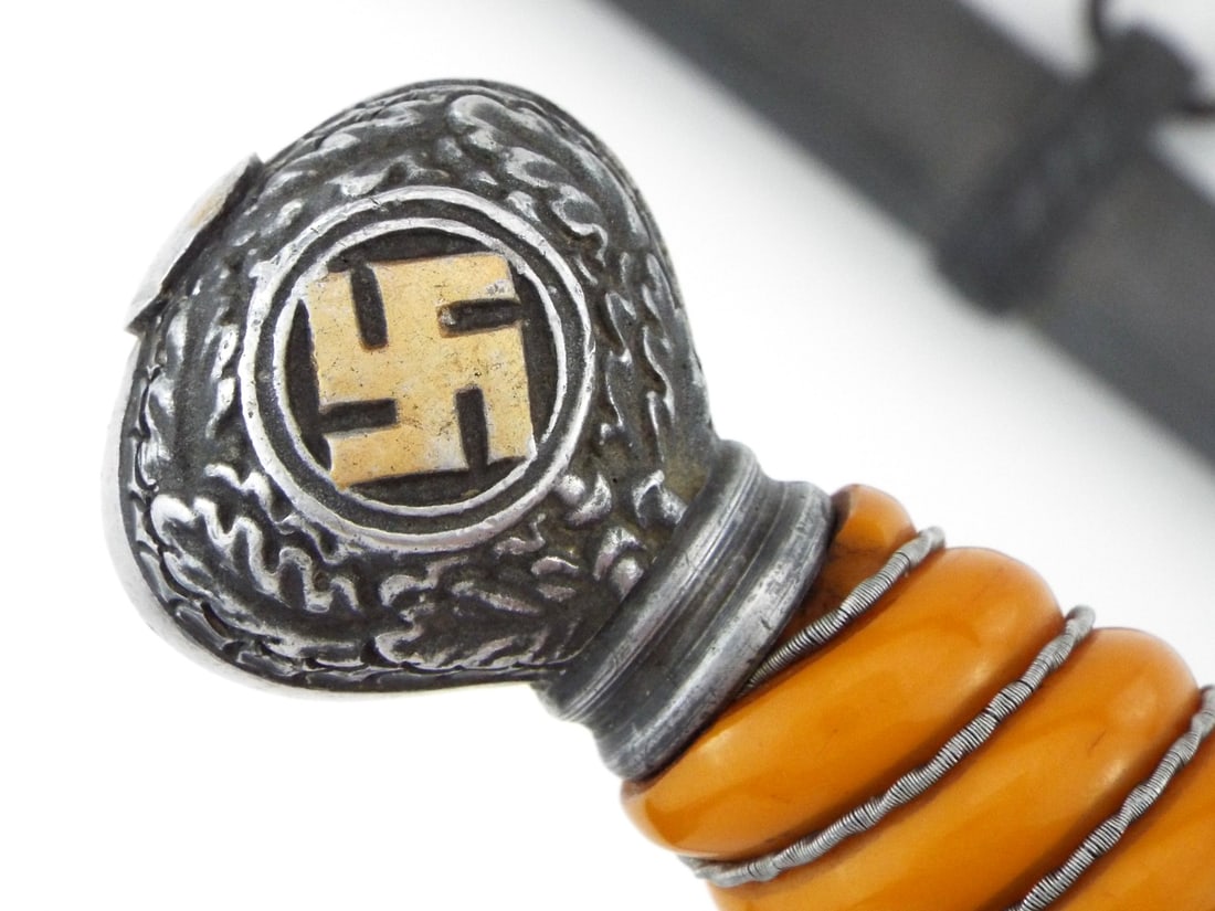 German WWII Luftwaffe Officer Dagger with Hand Engraved INSCRIPTION: Double edged dagger blade exhibits a bright polished finish showing minor surface scuffs. Orange celluloid spiral grooved grip features wire wrap, seated below an oak leaf decorated zinc alloy pommel 