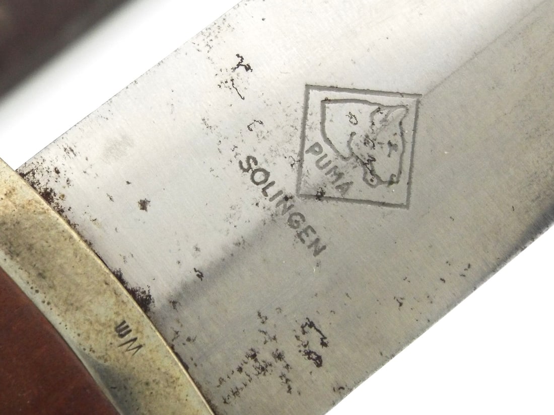 German WWII SA Dagger By PUMA SOLINGEN with Hanger: Early production steel blade shows scattered oxidation, graying, and the standard etched motto translated as All for Germany. The reverse ricasso bears the stamped Puma Solingen diamond maker mark. So