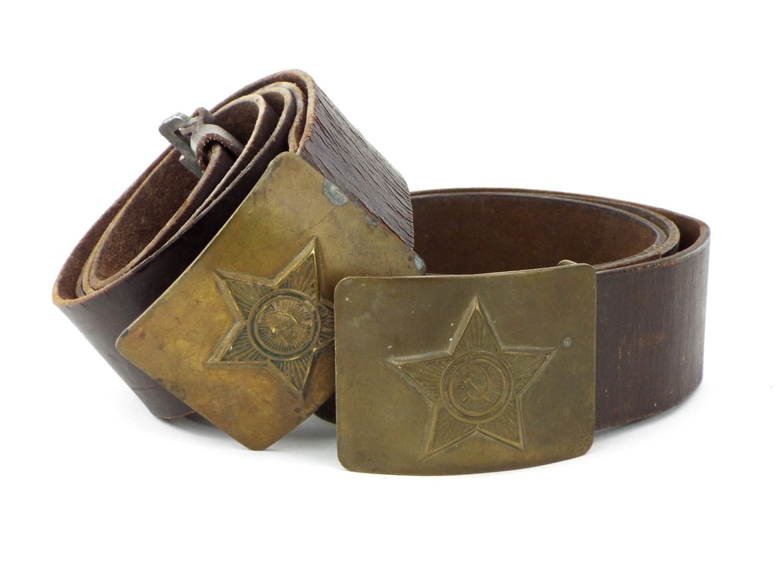 Pair of Soviet Cold War NCO Belts with Brass Buckles & Leather: Pair of Soviet Cold War era NCO soldier waist belts comprising a heavy brown leather strap exhibiting minor age wear and flexibility throughout, fitted with a brass rectangular buckle displaying a rai