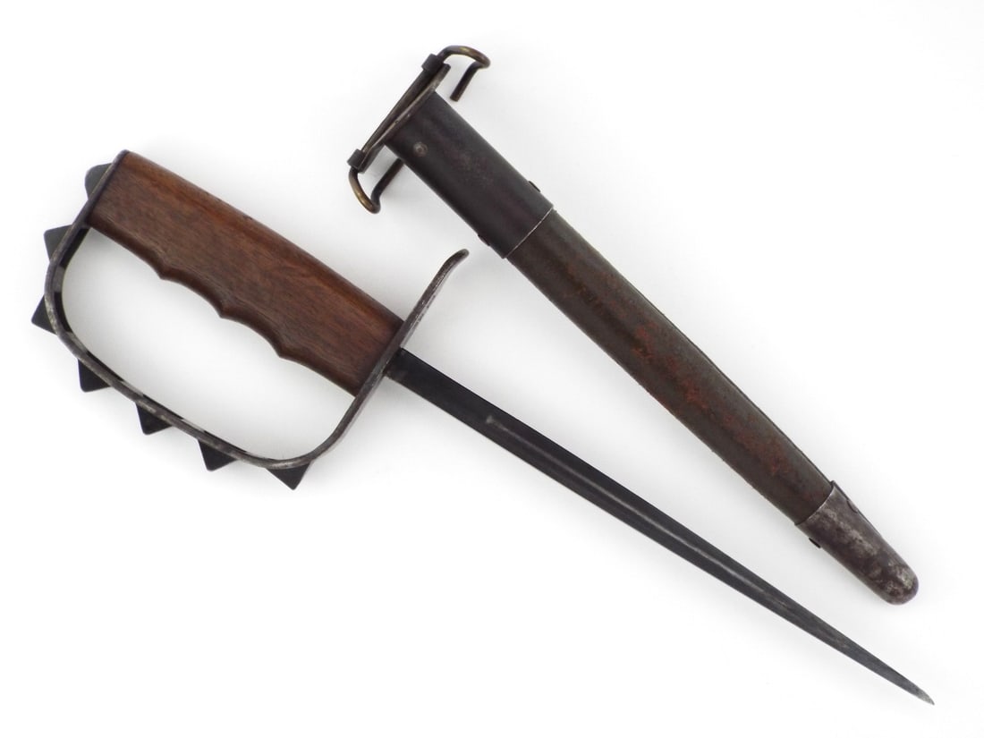 US WWI Trench Knuckle Duster Dagger By LF&C 1917 with Scabbard: Blued triangular stiletto spike blade displays minor surface oxidation and light runner wear. Walnut grip features crisp finger grooves flanked by a heavy steel D-ring guard with prominent pyramidal p