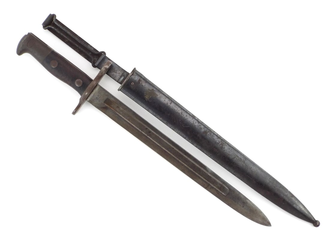 American WWI Krag Bayonet with Swiveling Belt Hanger: Straight single edged blade features deep fullers, displaying a dark, uncleaned patina with scattered oxidation, crisp US stamp and clear 1897 date. Muzzle ring guard and contoured walnut grip scales 