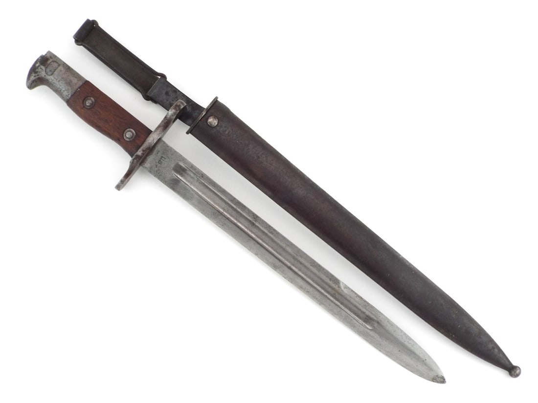 American WWI Krag Bayonet with Walnut Grips & Belt Hanger: Straight single edged steel knife blade with deep fullers exhibits scattered gray spotting and dark patina, stamped US on obverse ricasso and 1899 on reverse. Hilt retains contoured walnut wood grip s