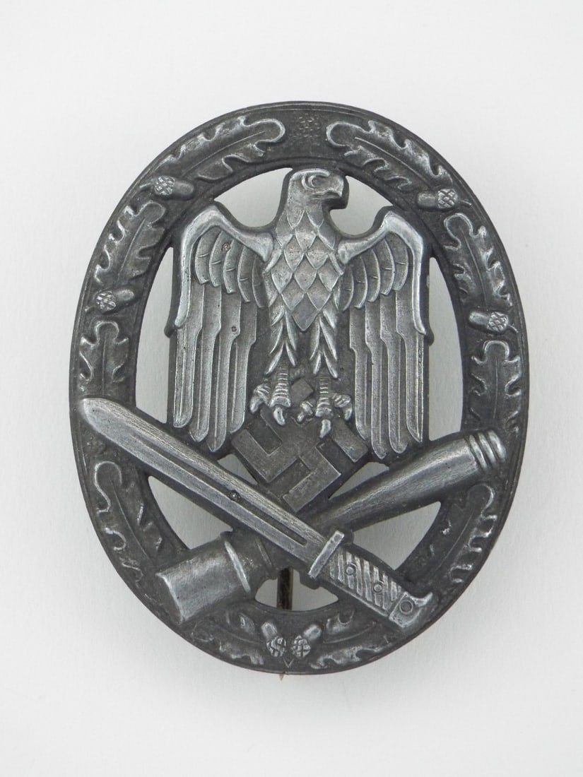 German WWII General Assault Badge By JFS Josef Feix & Sohne: Die struck zinc badge body exhibits crisp mid war detailing showing a deep gray patina and light oxidation throughout the oak leaf wreath, national eagle and crossed weaponry. Reverse features an uncl