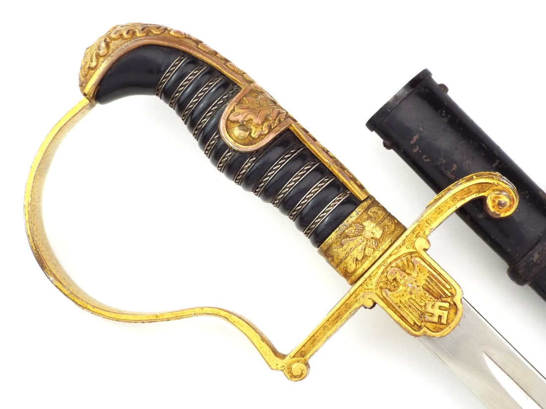 German WWII Officer Sword by Carl EICKHORN: Blade exhibits minor scuffs with the Carl Eickhorn squirrel trademark stamped under the langet. Gilded brass Dove head hilt displays thinning to high points on oak leaf relief with crisp eagle. Black 