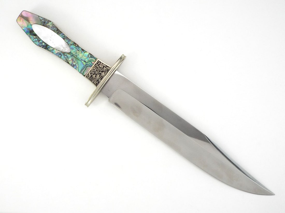 Rare American Custom Bowie Knife by FRANK VOUGHT Engraved Abalone & MOP Handle: High polish clip point blade displays a prominent swedge and F. Vought maker’s mark with very light surface patina. Hand engraved scrolling flourishes decorate the ferrule, joining a silver frame hi