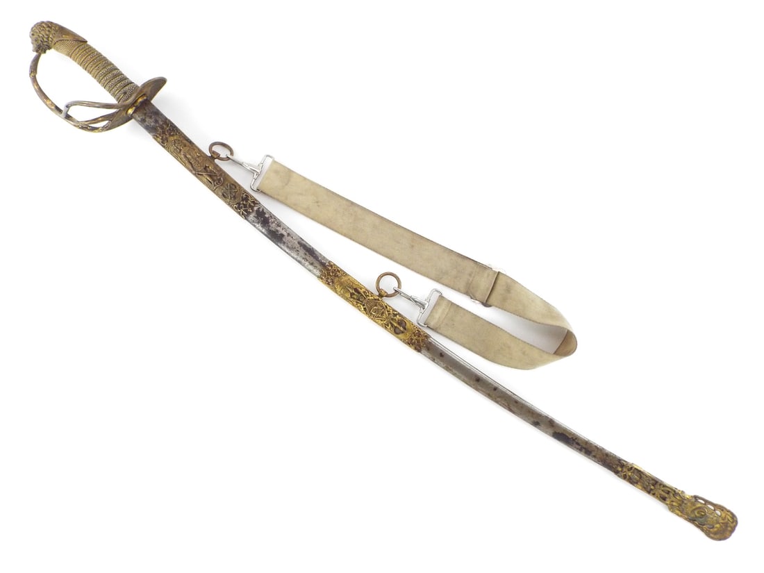 American Late 19th C. Fraternal Officer Sword By E.A. ARMSTRONG MFG. CO. with Hanger Strap: Slightly curved, single fullered steel sword blade features crisp engraved scrollwork displaying FCB shield motif, showing minor oxidation and light surface wear near the E.A. Armstrong Chicago maker