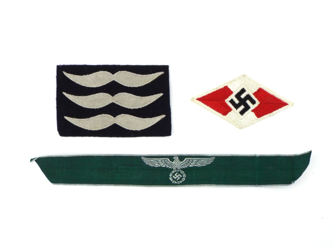 German WWII Insignia Group In Silver Bevo & Wool Construction: German WWII insignia group comprising a silver wire Bevo weave Police or Forestry sleeve eagle on green cloth backing showing minor glue residue to reverse, a Luftwaffe flight suit rank patch on dark 