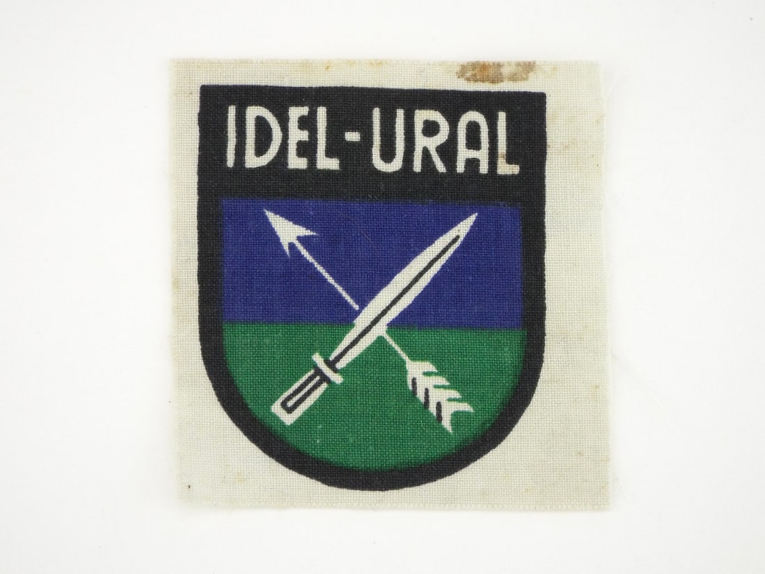 German WWII VOLGA-TATAR VOLUNTEER LEGION Patch: Woven white linen substrate exhibits light edge fraying and minor age staining along the top margin without material loss. Printed obverse design displays sharp registration of the blue and green cent
