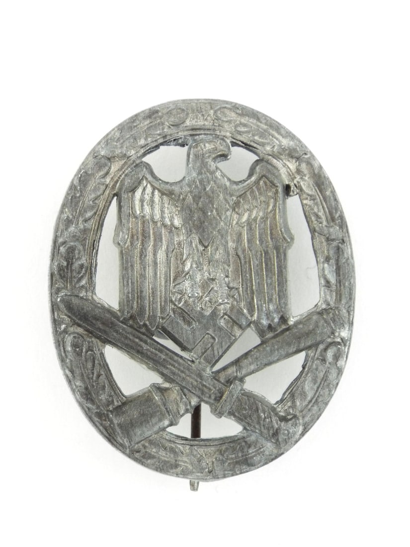German WWII General Assault Badge In Zinc Construction: Solid die cast zinc body featuring central eagle atop crossed bayonet and stick grenade surrounded by oak leaf wreath, displaying honest age toned gray patina with typical manufacturing rough edges. R