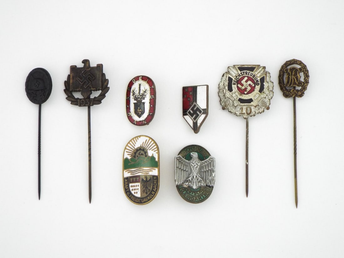 German WWII Grouping of 8 LAPEL PINS BADGES & TINNIES: Group of 8 civil, political and military lapel badges and stickpins featuring various enamel finishes and struck metal designs. Obverses exhibit light to moderate surface wear, crisp raised relief det
