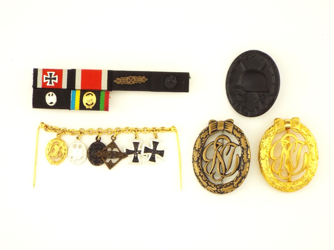 German WWII Medal Group: Consisting of a multi ribbon bar, two full sized German Sports Badges, a black Wound Badge and a gold dress miniature chain, this military award group displays uniform light surface wear, crisp die st