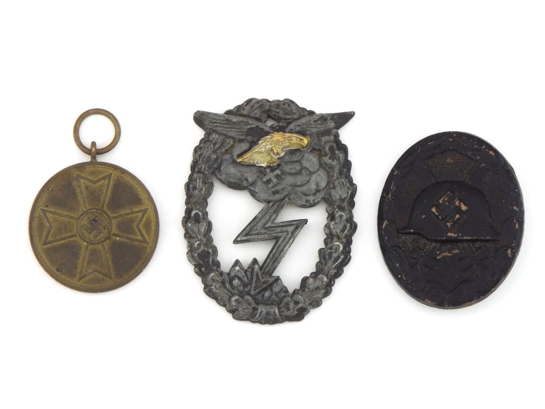 German WWII Medals Trio LUFTWAFFE War Merit & Wound badge: German WWII group of three awards comprising a Luftwaffe Ground Assault badge, War Merit medal and Wound badge in black. Die struck zinc ground assault badge displays expected finish loss to the obver