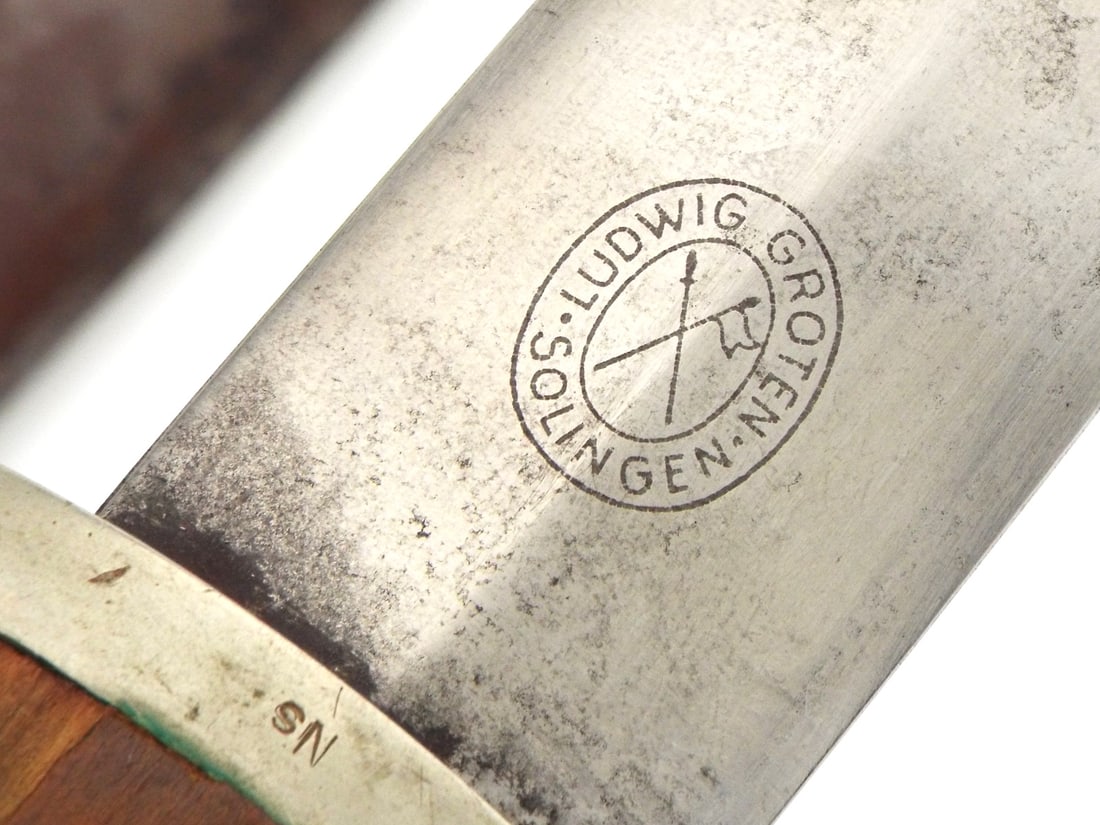 RARE MAKER German WWII Early SA Dagger By LUDWIG GROTEN: Double edged blade shows light surface runner marks and deep motto etching reading Everything for Germany, reverse ricasso bearing crisp oval maker mark. Browned wooden grip remains tight with embedde