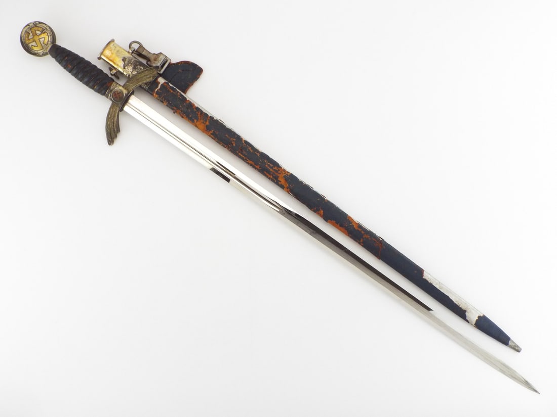 German WWII Early Luftwaffe Officer Sword By SMF SOLINGEN: Blade shows bright nickel finish with light surface wear, clear maker mark near ricasso and clean edges. Hilt features down curved feathered guard, brass sunwheel Insignia and leather wrapped grip ret