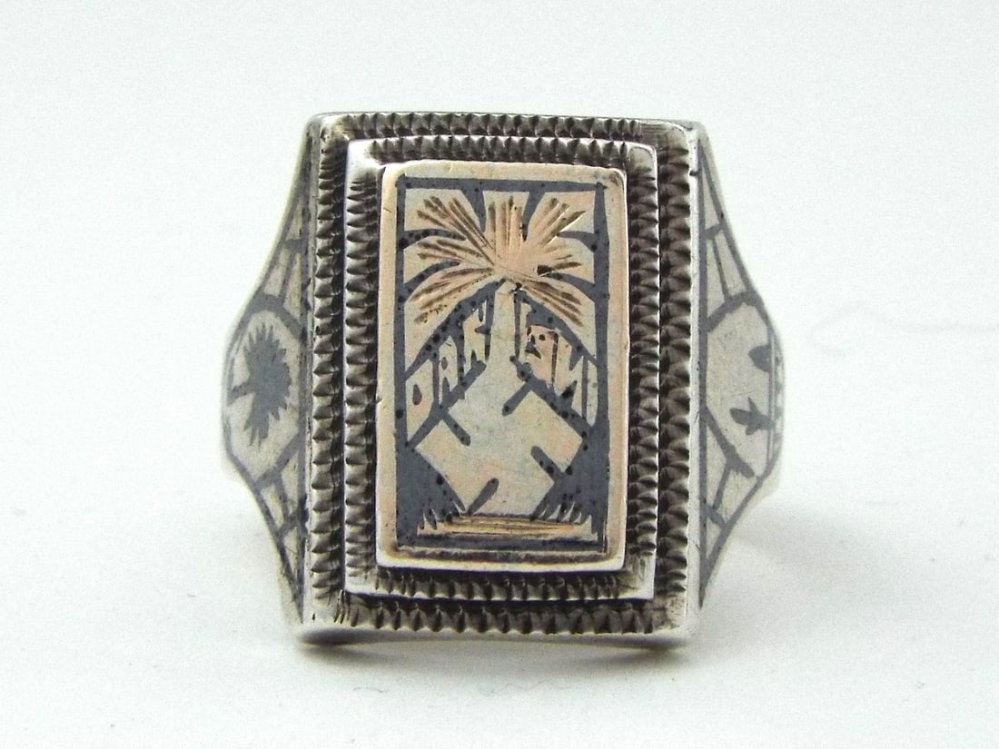 WWII German DAK AFRIKA KORPS North African Campaign Souvenir Ring: Constructed 80 percent grade silver ring features a raised rectangular central bezel set with a brass toned relief plate depicting a regional palm tree alongside wartime theater insignia over a steppe