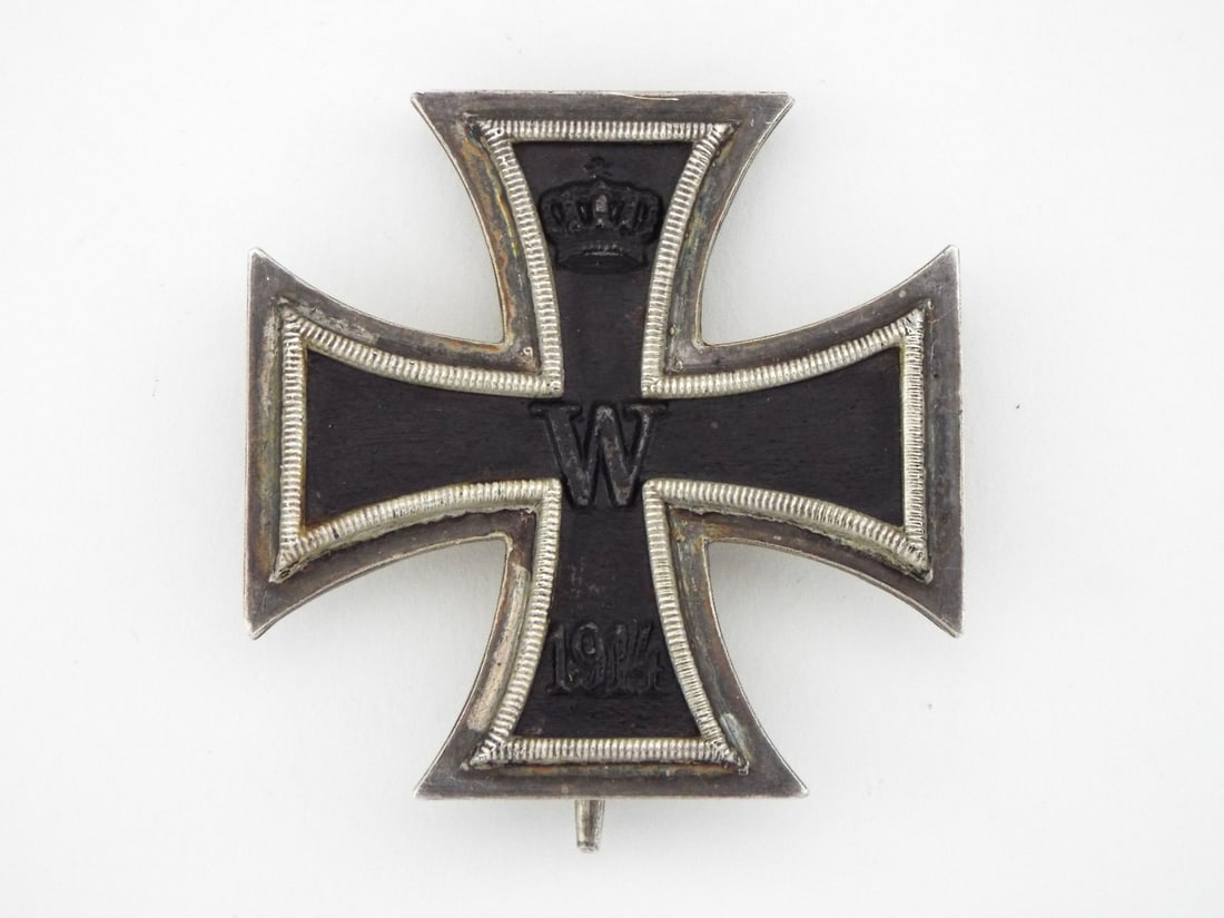 German WWI SY & WAGNER 1914 Iron Cross 1st Class Medal: Construction featuring a magnetic iron core with black enamel finish, showing royal crown above central monogram W and lower date 1914. Silver frame retains sharp beaded border work with moderate age 