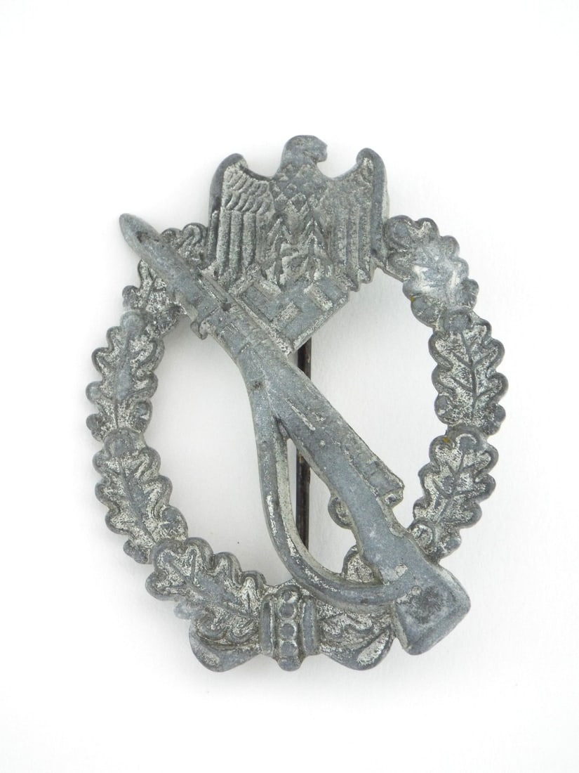 German WWII INFANTRY ASSAULT Badge with Intact Wire Attachment Pin: Die pressed zinc construction badge displaying expected surface toning, softening to detail throughout the obverse features. Reverse exhibits a semi hollow profile, intact catch and a round wire attac