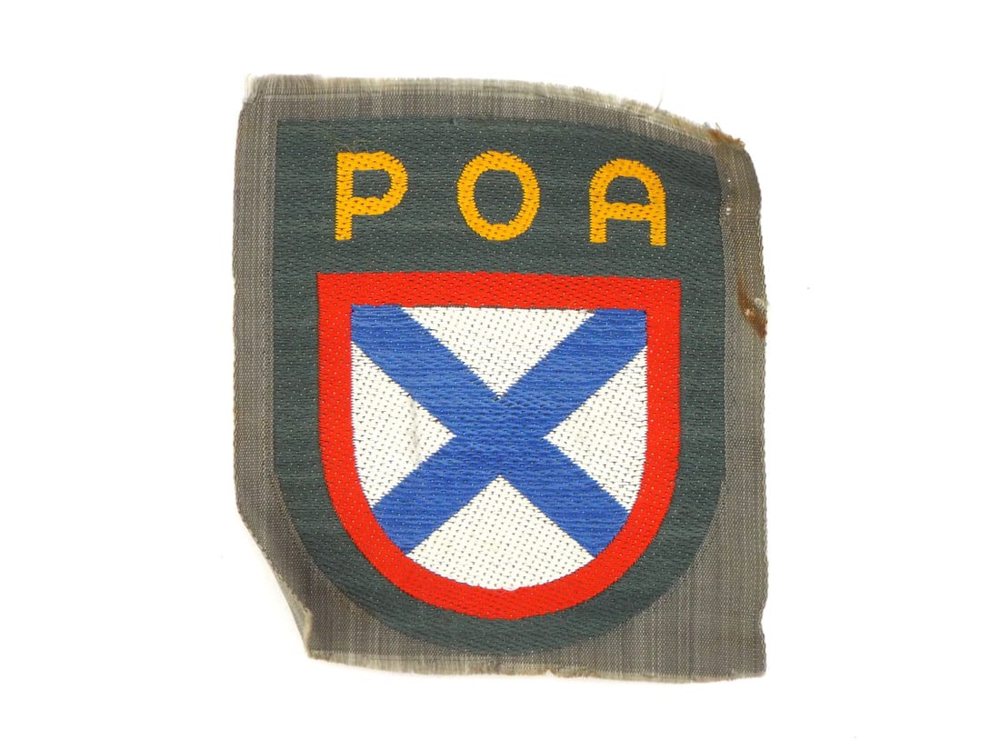 German WWII RUSSIAN LIBERATION ARMY VOLUNTEER Sleeve Shield Patch: Woven cloth patch displays embroidered Russian Liberation Army insignia with yellow letters reading POA set over shield featuring blue saltire on white field with red border. Front exhibits crisp thre