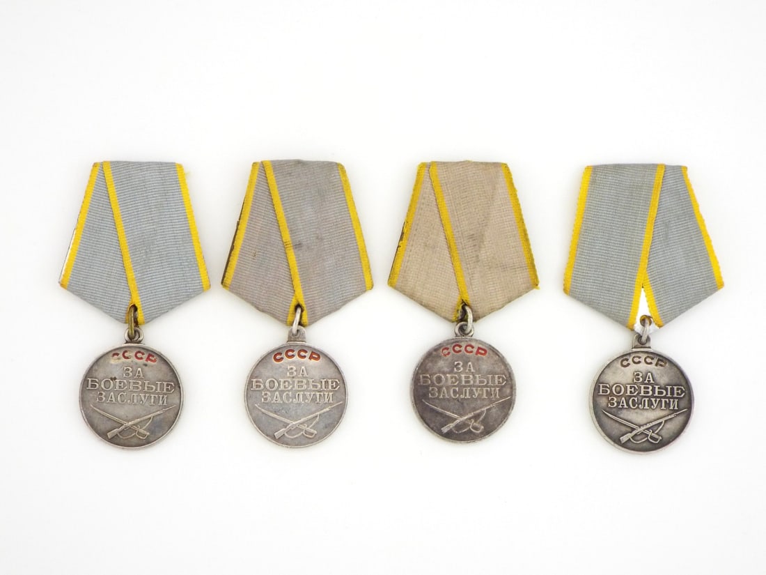 Soviet WWII Era Group of Four Combat Merit Medals Silver Struck: Group of four silver medals showing light surface wear and minor tarnishing, obverse displays red enamel lettering reading USSR with For Combat Merit and crossed rifle and sword, reverse shows stamped