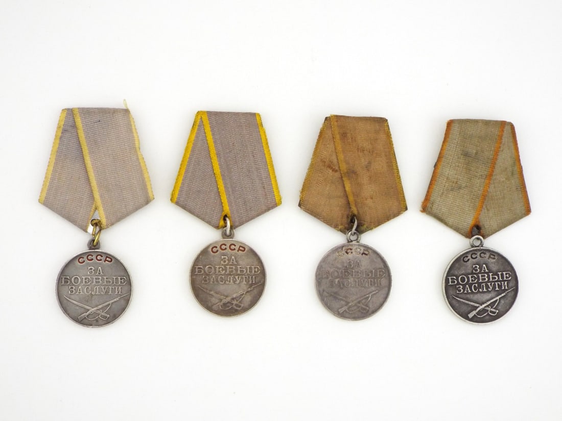 Soviet WWII Period Lot of Four Medals FOR BATTLE MERIT Silver Enamel: Four silver planchets exhibit varied toning, surface scuffing and minor rim nicks, each retaining the suspension ring to a pentagonal ribbon mount showing age staining and edge fraying. Obverses bear 