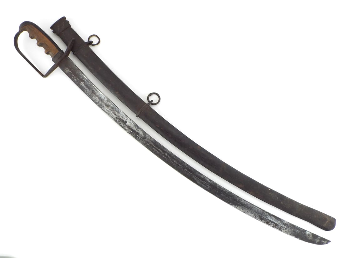 SELDOM ENCOUNTERED Italian WWI Dragoon Sword RARE Variant: Curved single edged blade features a wide full length fuller, presenting dark age patina and scattered surface darkening throughout. Simple flat iron stirrup guard securing a carved hardwood grip with