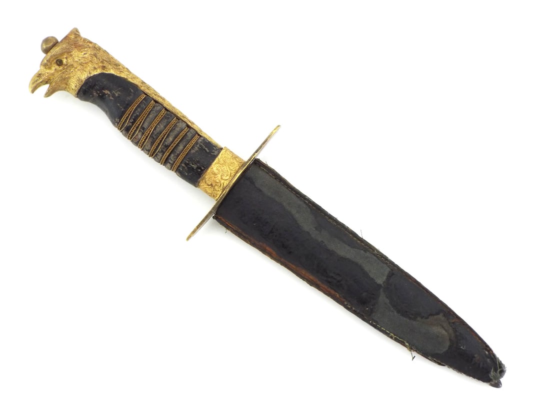Italian WWII Fascist Youth GIL Dagger Gilt EAGLE HEAD POMMEL: Spear point steel blade exhibits sharpening marks and minor edge wear. The hilt features a gilt brass eagle head pommel with a red glass eye, a filigree ferrule and a straight crossguard, securing a w
