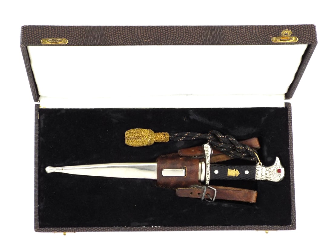 Romanian WWII CASED ARMY OFFICER DRESS DAGGER King Michael I: Nickel finish blade shows minor runner marks. Checkered celluloid grip plates feature the gilt royal cipher of King Michael I secured by two rivets. Silvered eagle head pommel retains bezel set red gl