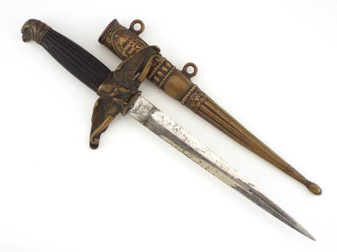 Hungarian WWII Royal Hungarian AIR FORCE Officer Dagger & Brass Scabbard: Straight double edged diamond section blade exhibits localized dark mottling, light surface pepper and faint stamped maker markings beneath a crowned shield proof. Cast brass crossguard shaped as a
