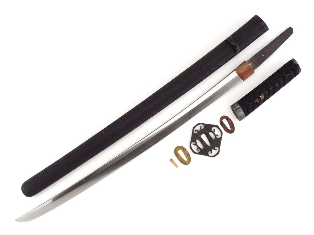 Japanese Edo Era Wakizashi Sword with Iron Sukashi Tsuba: Unsigned single edged curved blade exhibits light surface patination, a visible hamon line and an unpolished tang with a single peg hole. Plain iron tsuba features openwork scroll cutouts alongside a 