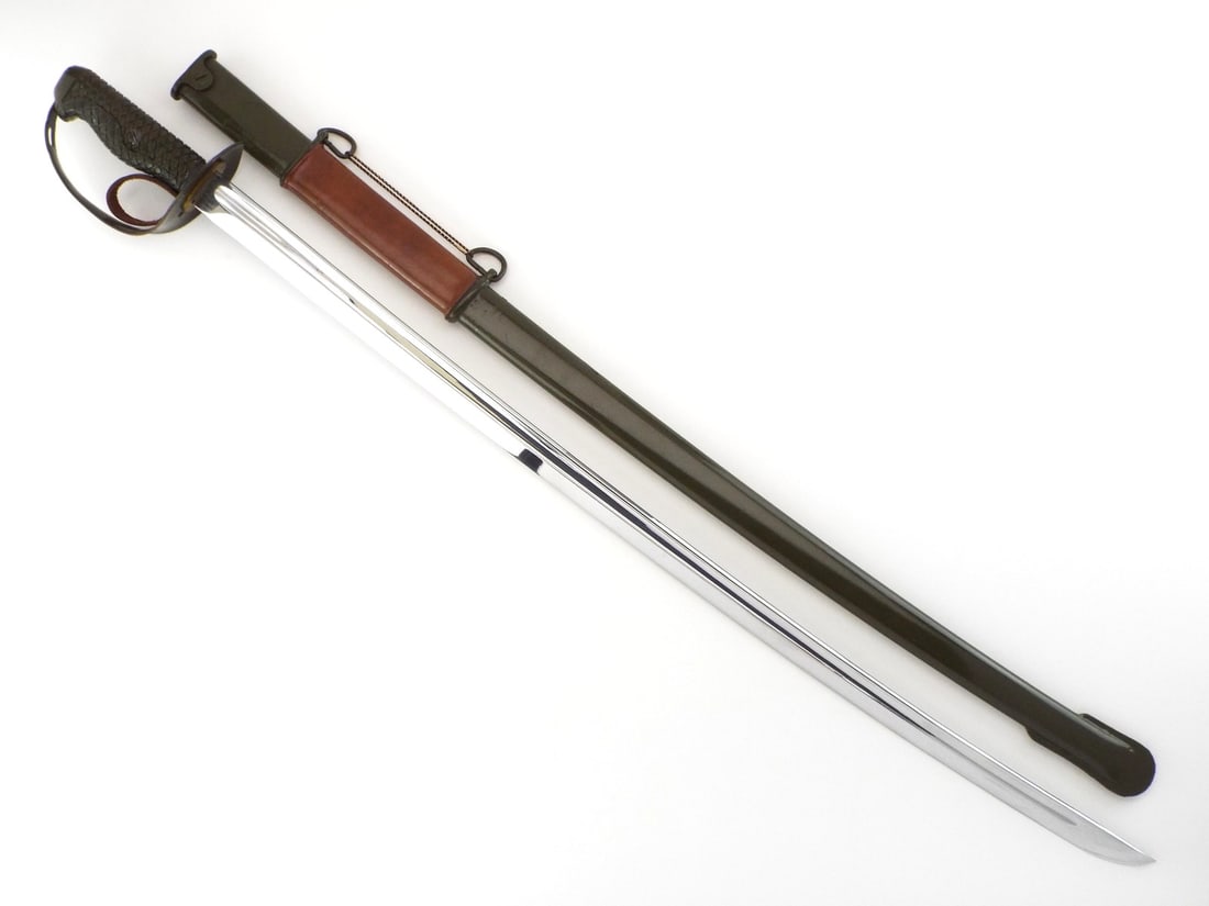 UNISSUED CONDITION Chinese Cold War PLA Type 65 Cavalry Sword: Bright polished steel blade with single fuller exhibits light storage wear and factory edge, featuring serial number stenciled at ricasso. Olive drab painted steel guard and checkered grip remain pris