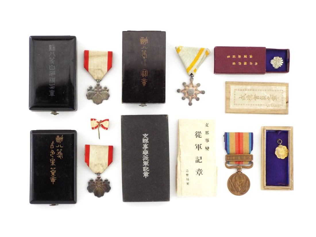 Lot of Japanese MILITARY DECORATIONS with Silver & Bronze Merit Awards: Imperial group comprising two Eighth Class Order of the Rising Sun in silver with paulownia leaf motifs, one Eighth Class Order of the Sacred Treasure with mirror design and one 1937 China Incident Wa