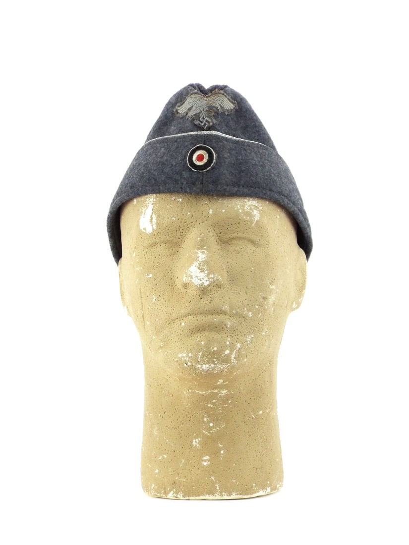 German WWII LUFTWAFFE OFFICER Side Cap: Grey wool body shows minimal surface nap wear. Silver aluminum piping remains tight. Hand applied bullion eagle exhibits heavy fraying and loss to wire highlights. Machine embroidered national cockade