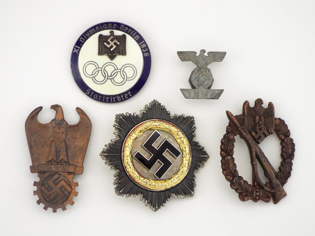 German POST WWII Mixed Medals and Insignia Grouping: Varied assembly of Post WWII badges displaying expected age patina and moderate surface wear. Centerpiece star pin retains gilt finish surrounding crisp black enamel insignia, accompanied by early 193