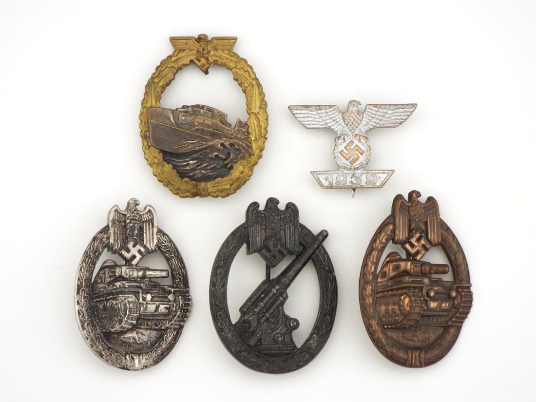 German POST WWII Military Badge Lot: Metal combat decorations featuring an E-boat clasp marked S. CH. FREI BERLIN 68 with heavy gilt wear, a 1939 Iron Cross clasp, a silver tank assault badge marked FRANK & REIF STUTTGART showing high po