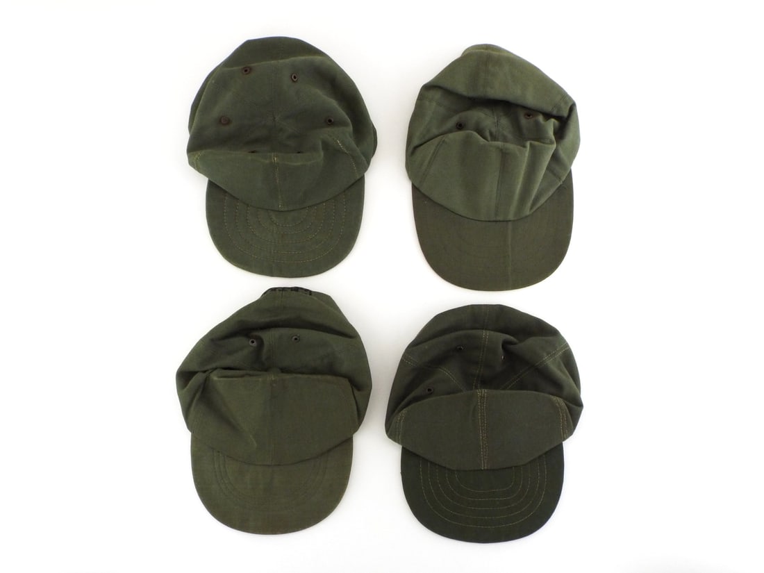 Grouping of US Post WWII-Vietnam War FIELD CAPS: Olive green cotton poplin body panels exhibit mild fading, localized fold creasing and minor surface soil consistent with field use, retaining dark finish on metal ventilation eyelets. Interior featur