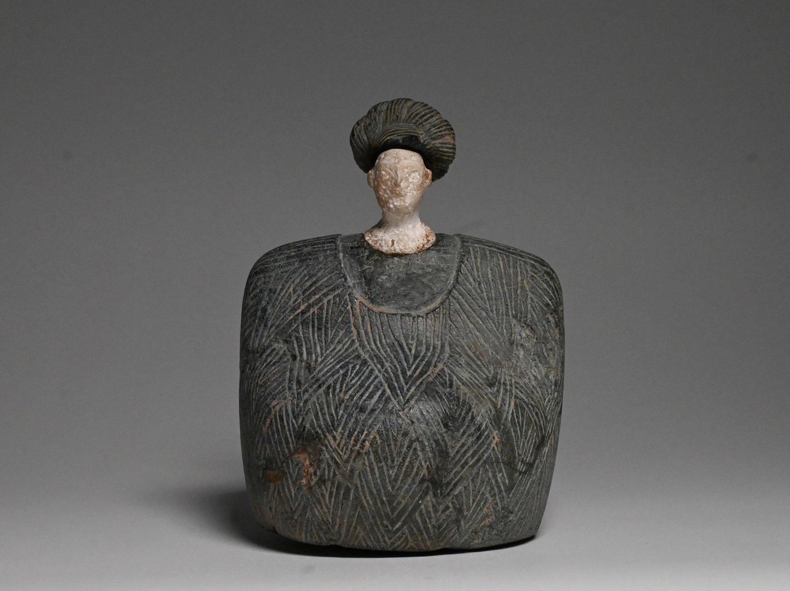 A Bactrian composite Seated female figure: Bactria-Margiana Archaeological Complex ca. late 3rd-early 2nd millennium BCEComposed of a dark gray chlorite body and a white stone head and neck, the body with rounded shoulders and a shelf-like lap