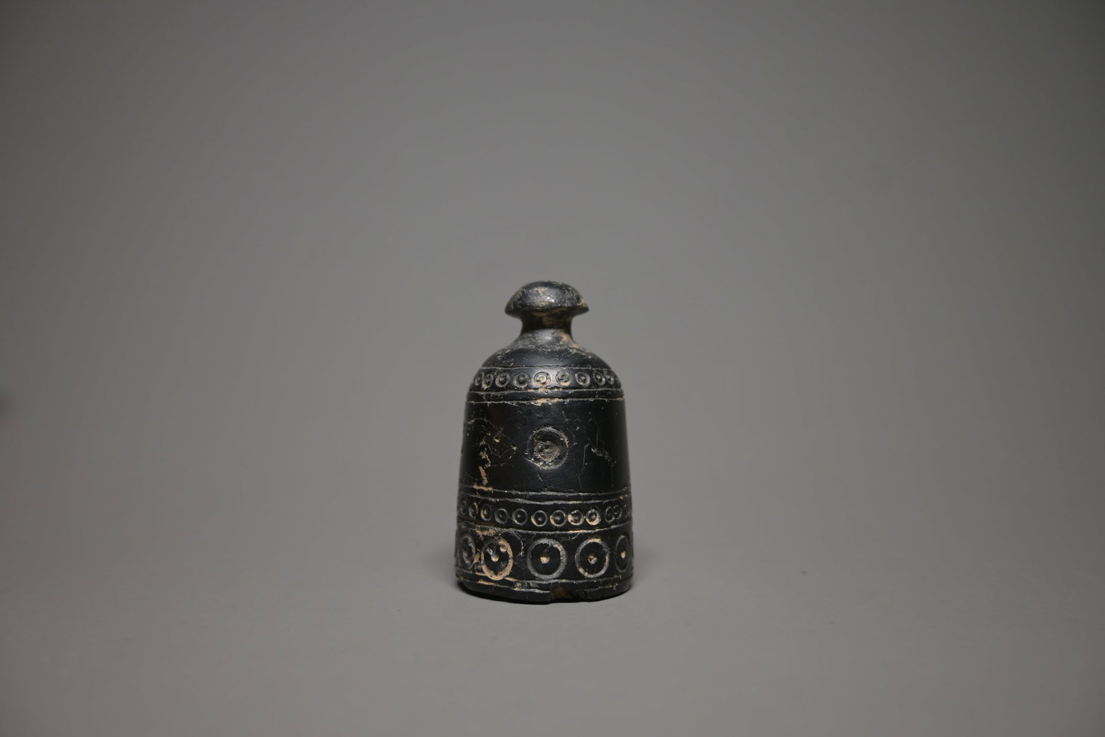 A jet games piece, probably pawn, early islamic: Rare jet gaming piece, probably a chess pawn (baidaq), Islamic world, circa 8th–9th century CE. Finely carved from deep black jet stone in a domed cylindrical form, the piece is decorated with caref