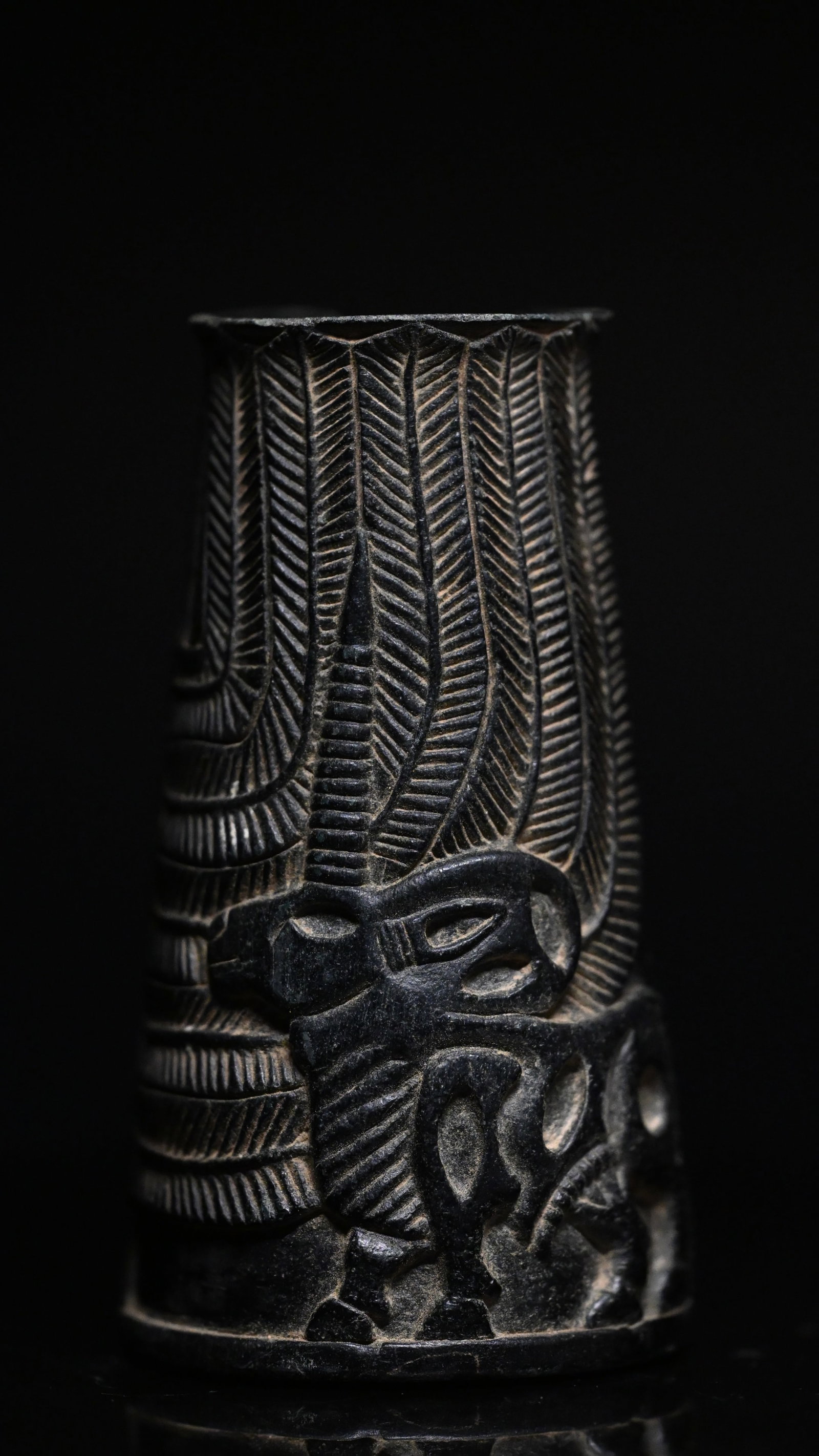 A bactrian cup or vessel with zebu bulls: Bactrian / Jiroft Chlorite Beaker with bulls and palm tree.Late 3rd–Early 2nd Millennium B.C.A finely carved dark grey-black chlorite vessel of slightly tapering cylindrical form, decorated in low r
