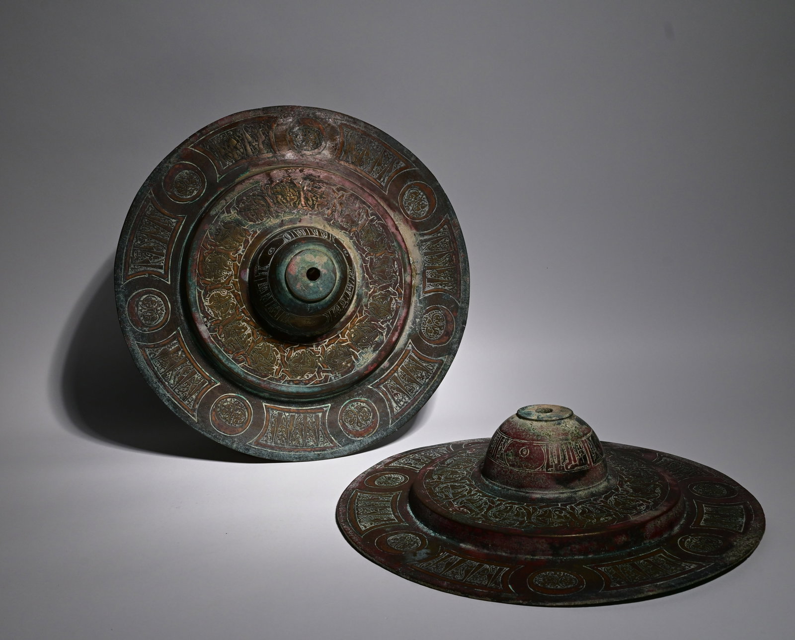 Khorasan Engraved and Copper-Inlaid Pair of Bronze Bosses Persia, 12th–13th Century: Khorasan Engraved and Copper-Inlaid Pair of Bronze BossesPersia, 12th–13th Century.Size: 27cm diameter Provenance: property of an private european collector, acquired in early 1990s.